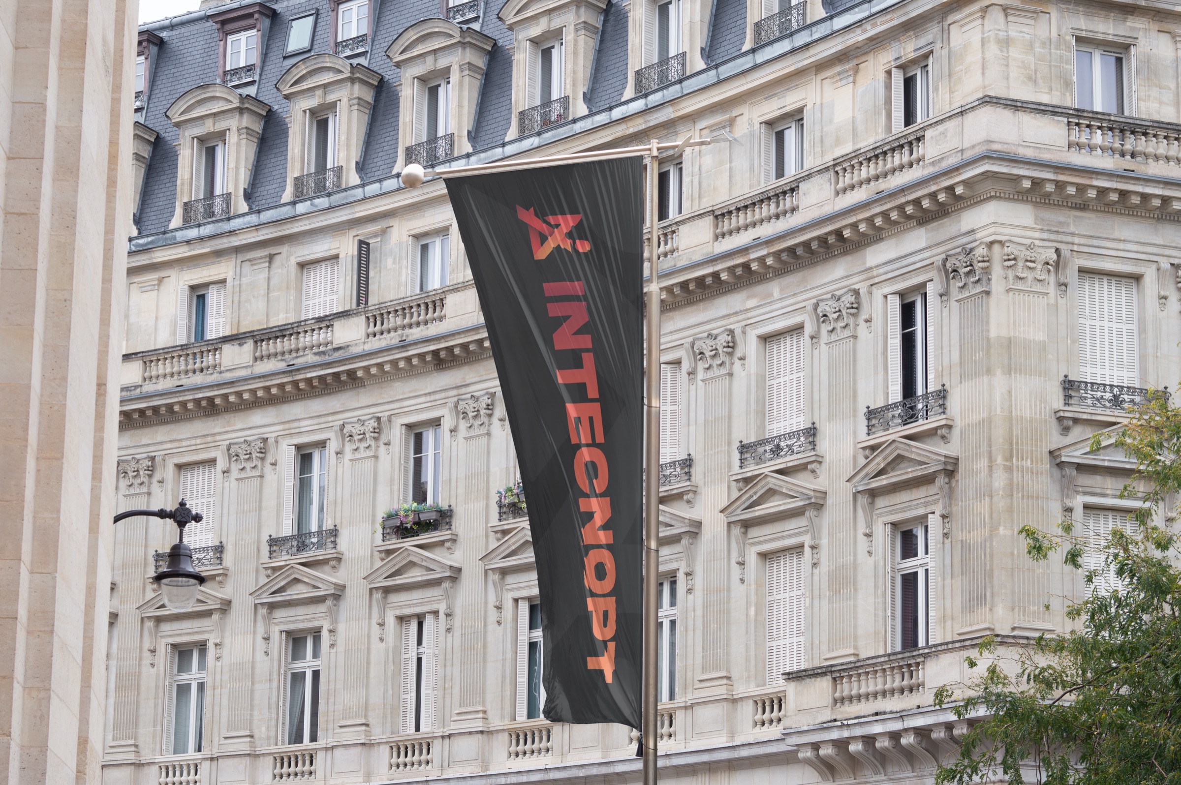 Bandeira da Intecnopt em frente a um edifício clássico