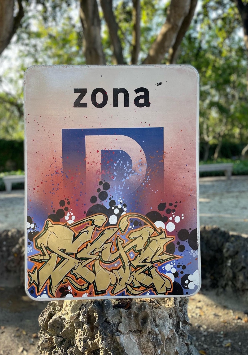 Sinal de estacionamento pintado com letras de graffiti douradas